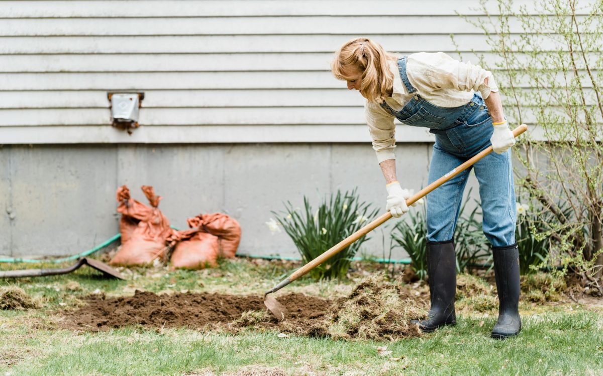 Woman Wearing Denim Overalls and Wellies Gardening